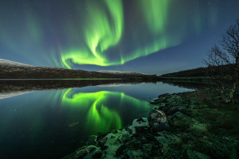 Northern Lights shining over a lake in Norway