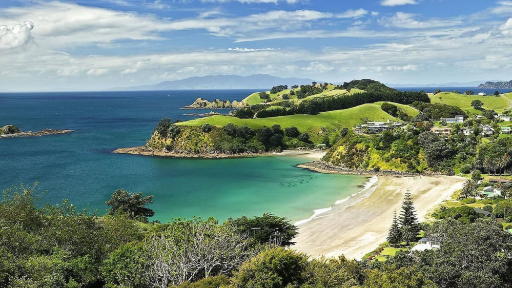Aerial view of Waiheke Island with turquoise water, sandy beaches, and green coastline near Auckland, New Zealand.